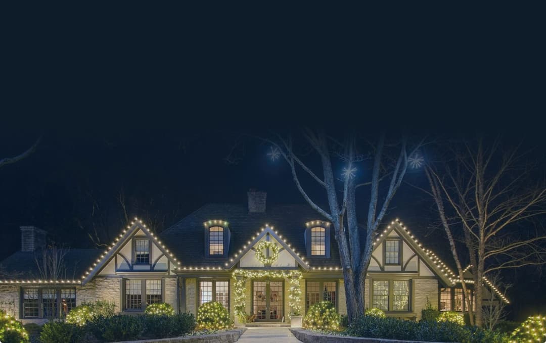 A home lit with warm white lights on every roofline